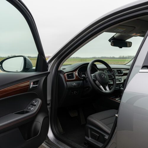 Die offen stehende Fahrertür eines parkenden Wagens visualisiert die rechtliche Auseinandersetzung um die Haftungsquote und die Betriebsgefahr, die nach einer Kollision durch eine plötzlich geöffnete Fahrzeugtür entsteht.